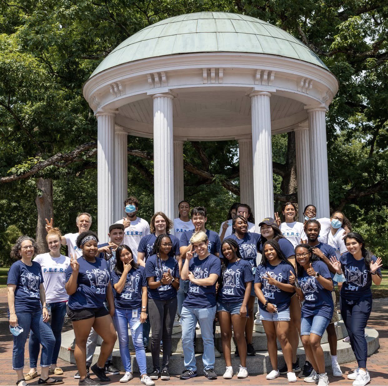 24 diverse students and 2 faculty standing by old well for UNC SURE 2021 program