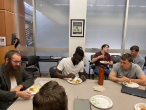 diverse students and faculty and others eat at a shared table
