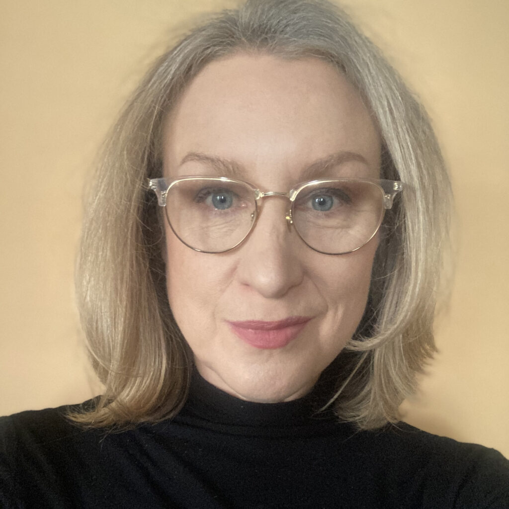 Lisa Domby, woman wearing glasses with shoulder length blonde hair wearing a black shirt.